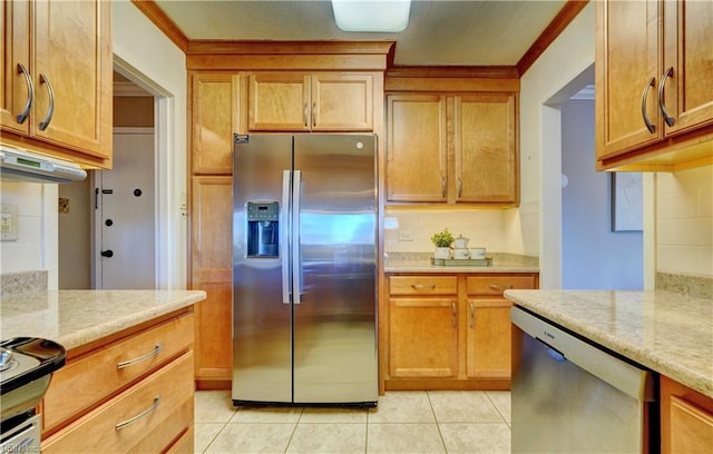 kitchen with appliances with stainless steel finishes, tasteful backsplash, light tile patterned flooring, and light stone counters