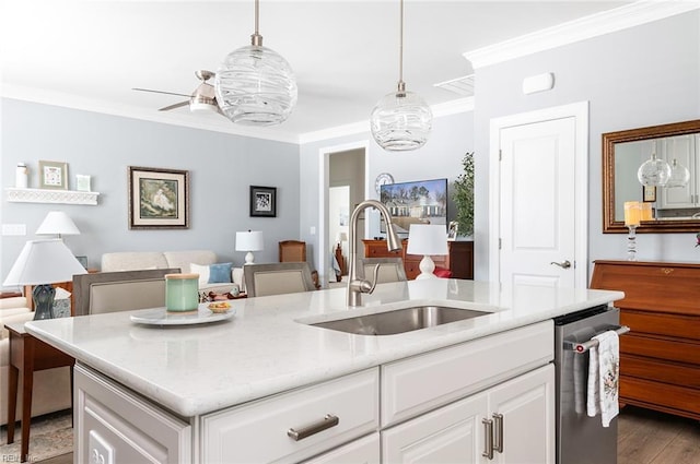 kitchen with ornamental molding, white cabinetry, a sink, and decorative light fixtures