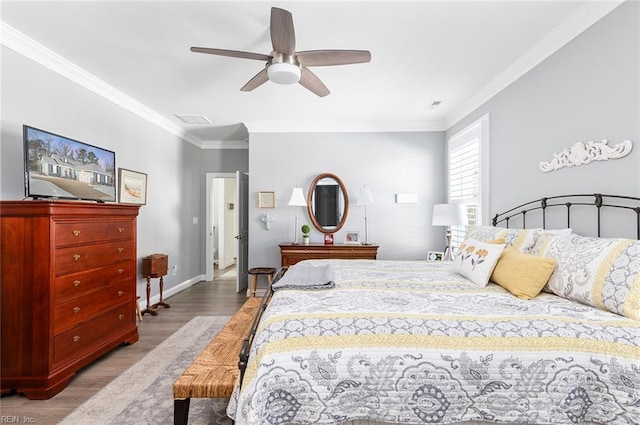 bedroom with light wood finished floors, baseboards, visible vents, a ceiling fan, and crown molding