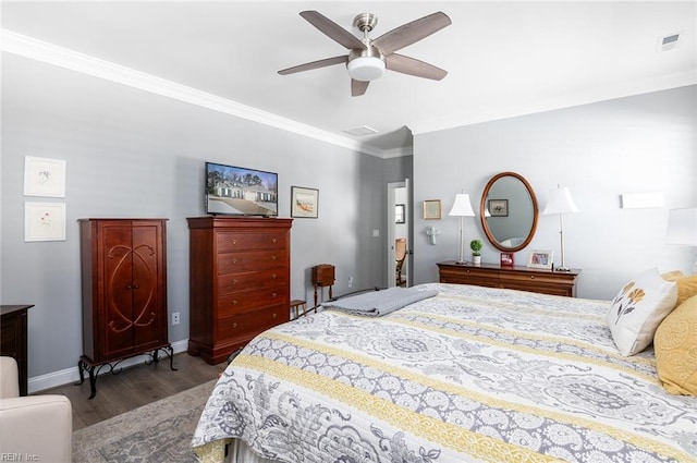 bedroom featuring baseboards, wood finished floors, visible vents, and crown molding