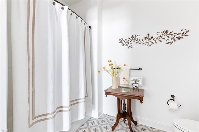 full bathroom featuring toilet, baseboards, and tile patterned floors