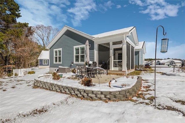 snow covered property featuring a sunroom