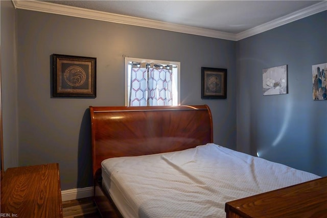 bedroom featuring crown molding, baseboards, and wood finished floors