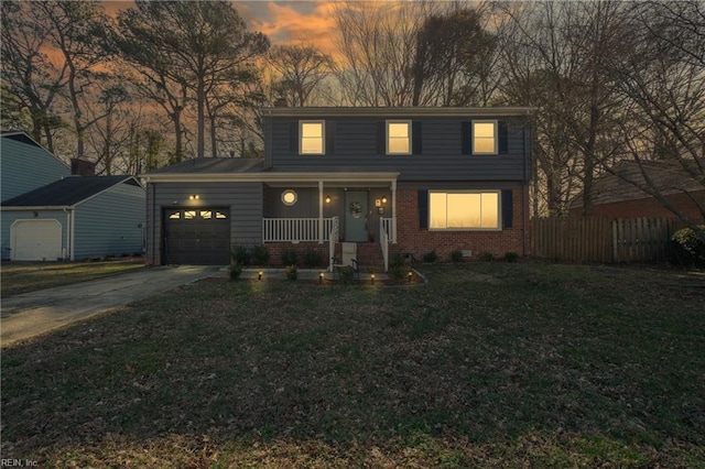 view of front property with covered porch, a yard, and a garage