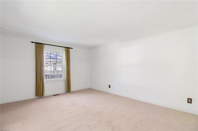 carpeted spare room featuring visible vents and crown molding