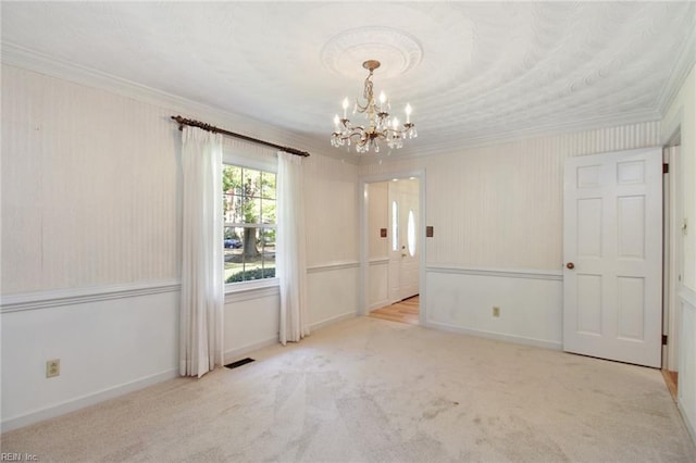 spare room featuring light carpet, crown molding, visible vents, and a notable chandelier