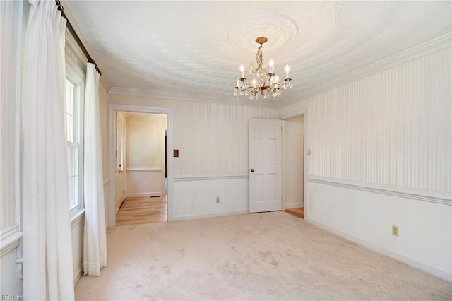 empty room with crown molding, light carpet, and a notable chandelier