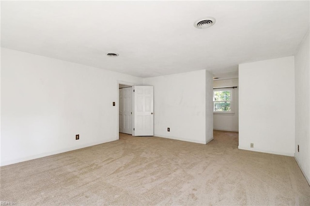 spare room with light colored carpet and visible vents