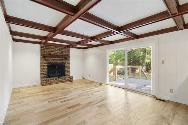 unfurnished living room featuring light wood-style floors, visible vents, beamed ceiling, and coffered ceiling