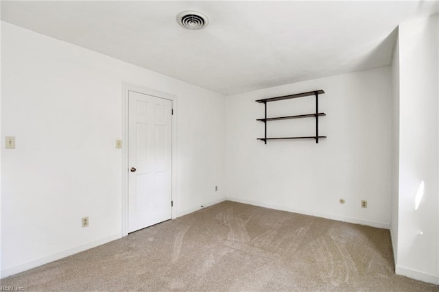 spare room with light carpet, visible vents, and baseboards