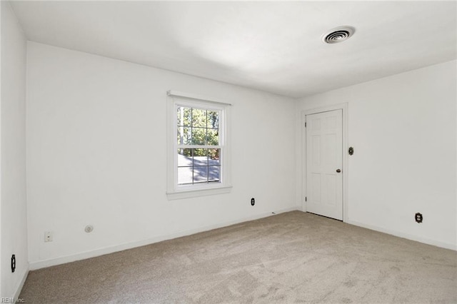 unfurnished room featuring baseboards, visible vents, and light colored carpet