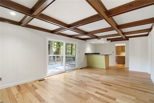 unfurnished living room with light wood-type flooring, visible vents, coffered ceiling, and beamed ceiling