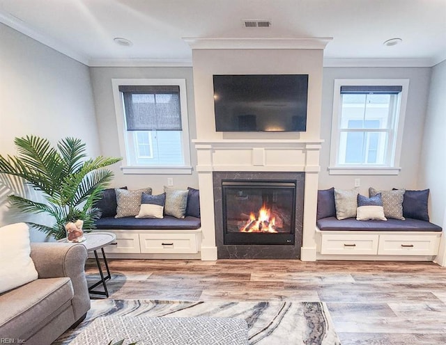 living area featuring ornamental molding and light wood-type flooring