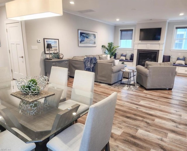 dining area featuring light hardwood / wood-style floors and crown molding