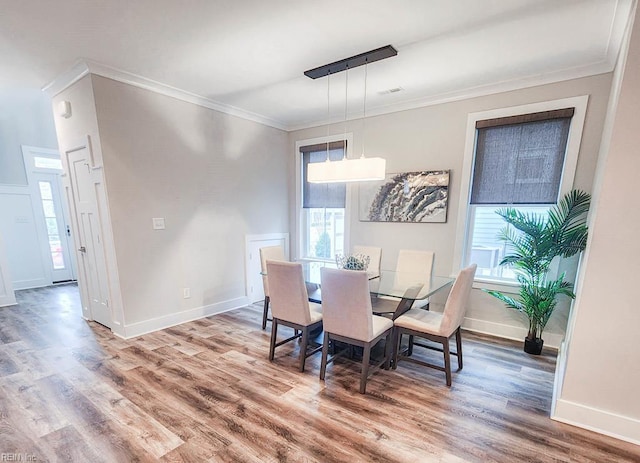 dining room with crown molding and wood-type flooring