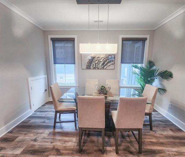 dining area with ornamental molding and dark hardwood / wood-style flooring