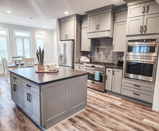 kitchen with appliances with stainless steel finishes, gray cabinets, and wood-type flooring