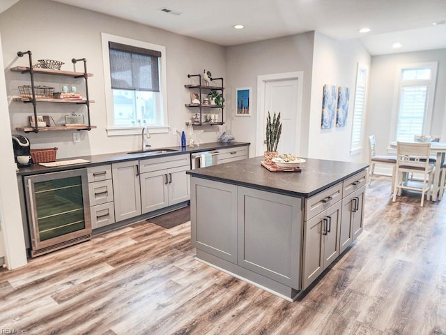 kitchen featuring wine cooler, a center island, sink, and gray cabinets