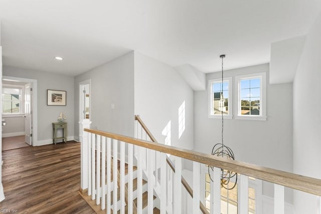 hall featuring dark hardwood / wood-style flooring, plenty of natural light, and a chandelier