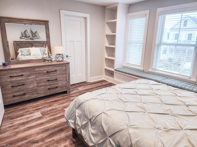 bedroom with multiple windows and wood-type flooring