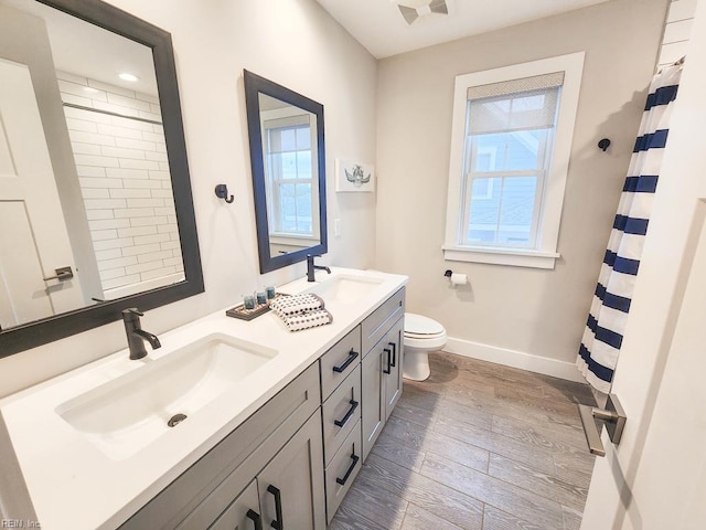 bathroom with toilet, vanity, plenty of natural light, and wood-type flooring