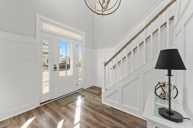 foyer entrance with dark hardwood / wood-style floors and a notable chandelier