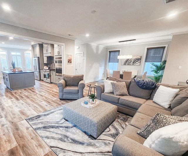 living room featuring light hardwood / wood-style flooring and crown molding