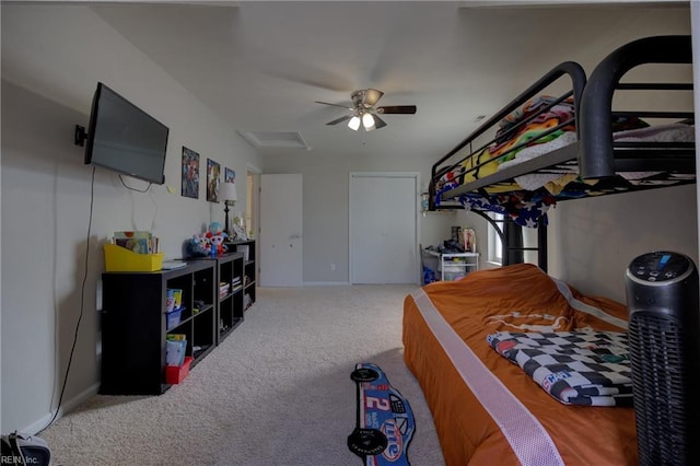 bedroom featuring attic access, ceiling fan, and light colored carpet