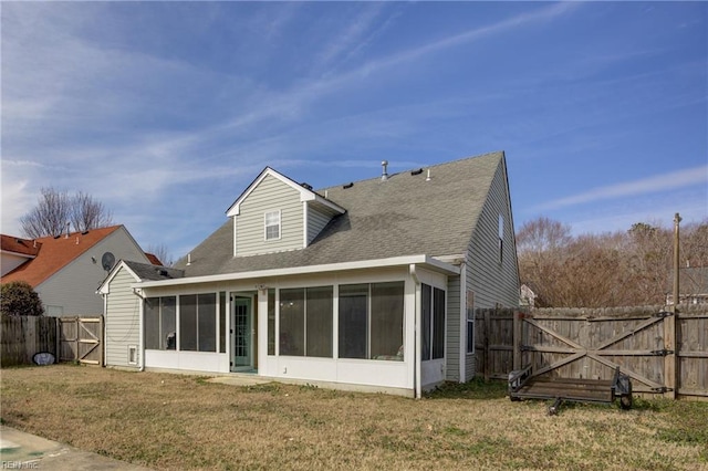 back of house featuring a yard, a shingled roof, a sunroom, a gate, and a fenced backyard