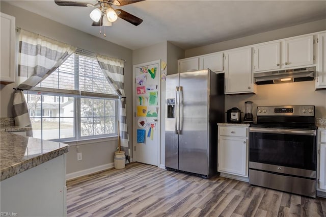 kitchen with stainless steel appliances, light stone countertops, white cabinetry, and under cabinet range hood