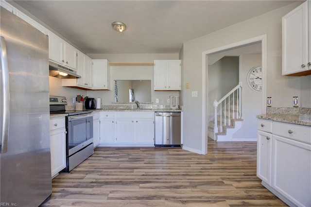 kitchen with stainless steel appliances, under cabinet range hood, and white cabinets