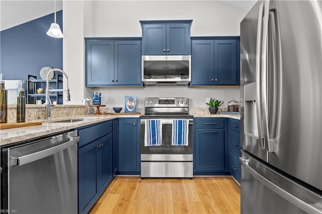 kitchen featuring light wood-style flooring, appliances with stainless steel finishes, blue cabinets, hanging light fixtures, and a sink