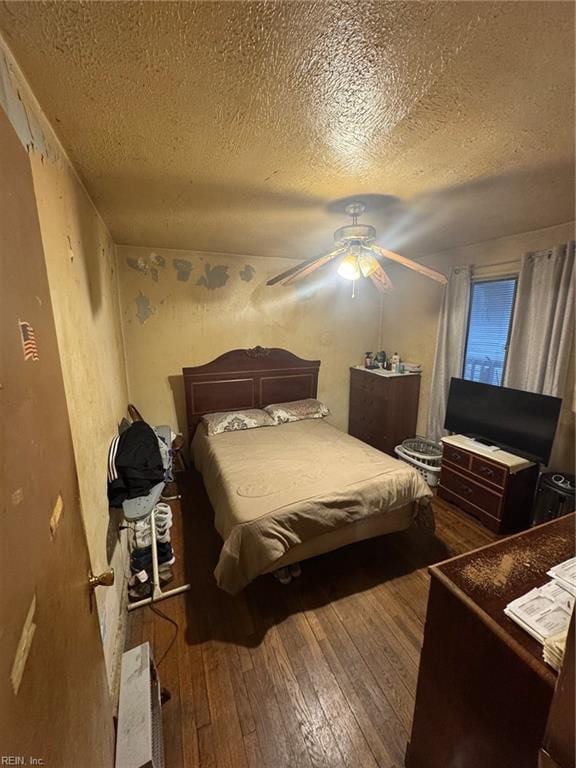 bedroom with a textured ceiling, hardwood / wood-style floors, and ceiling fan
