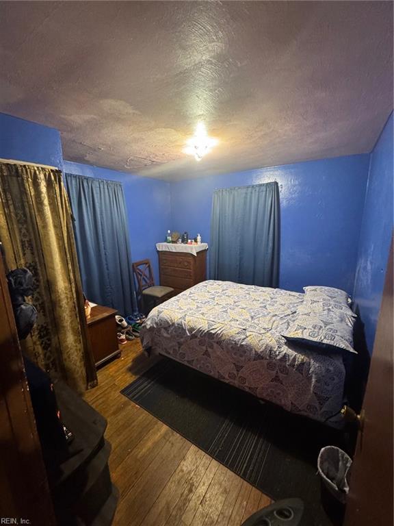 bedroom featuring a textured ceiling and hardwood / wood-style floors