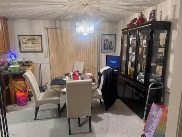 dining room featuring a notable chandelier, a textured ceiling, and light colored carpet