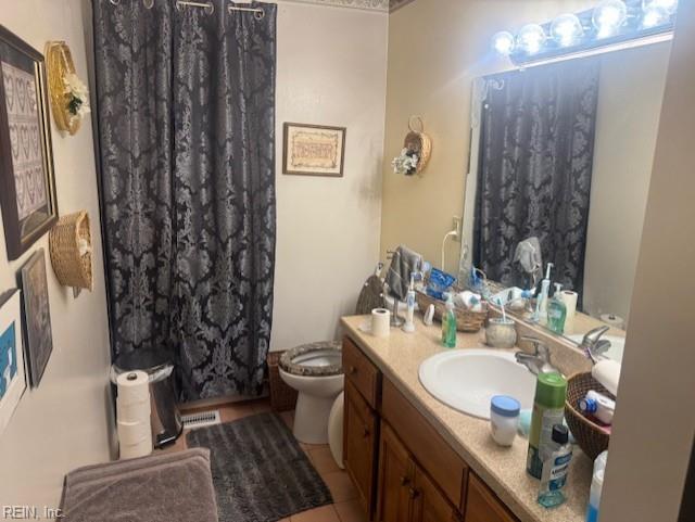 bathroom featuring a shower with shower curtain, vanity, tile patterned flooring, and toilet