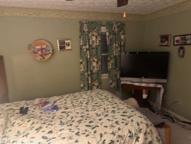 bedroom featuring ceiling fan and a textured ceiling