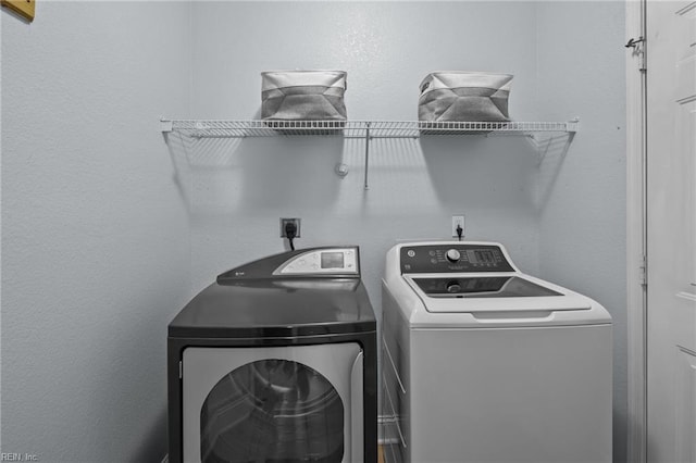 clothes washing area with washer and clothes dryer