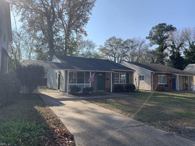 ranch-style house featuring covered porch, a front lawn, and a carport