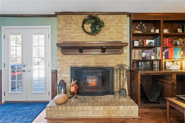 details featuring french doors, a brick fireplace, and crown molding