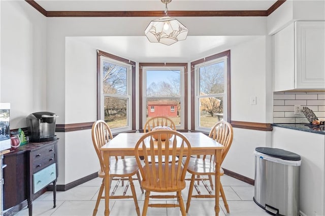 tiled dining room featuring crown molding