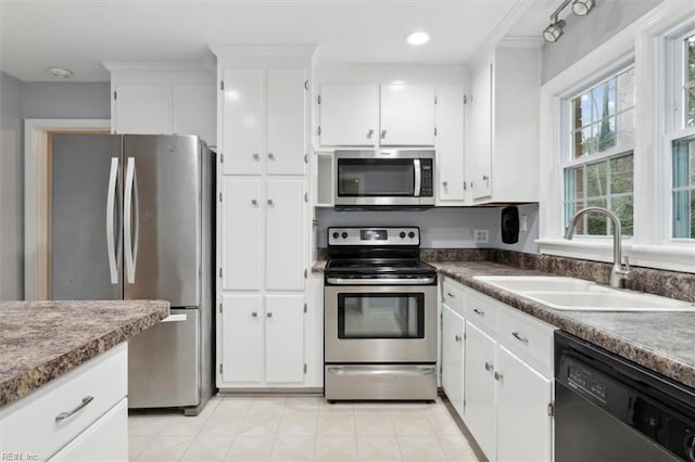 kitchen with appliances with stainless steel finishes, sink, and white cabinetry
