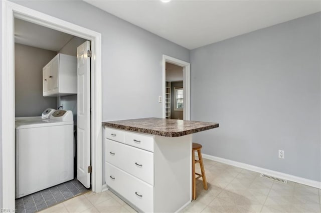 laundry area featuring washing machine and dryer and cabinets