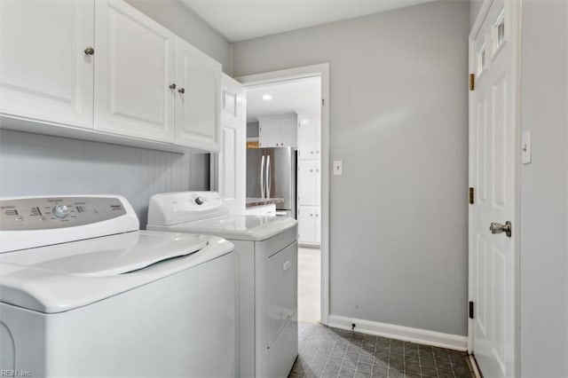 clothes washing area with washer and clothes dryer and cabinets