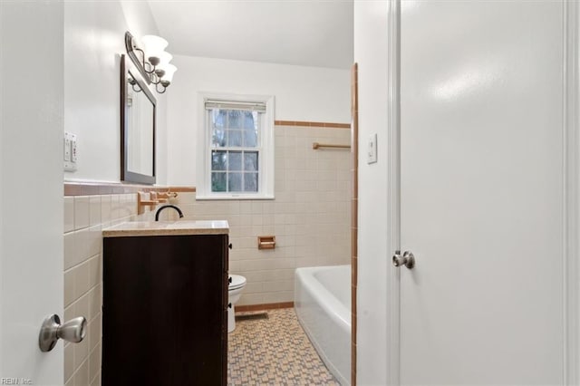 bathroom with toilet, tile walls, and vanity