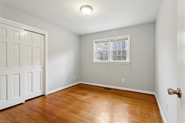 unfurnished bedroom featuring a closet and wood-type flooring