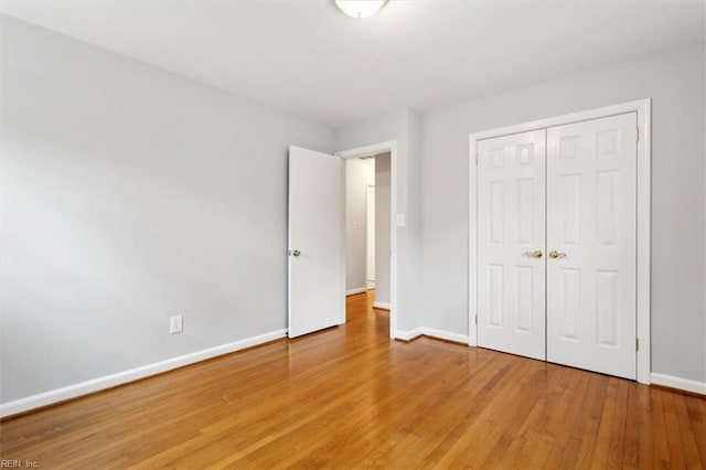 unfurnished bedroom with a closet and hardwood / wood-style flooring