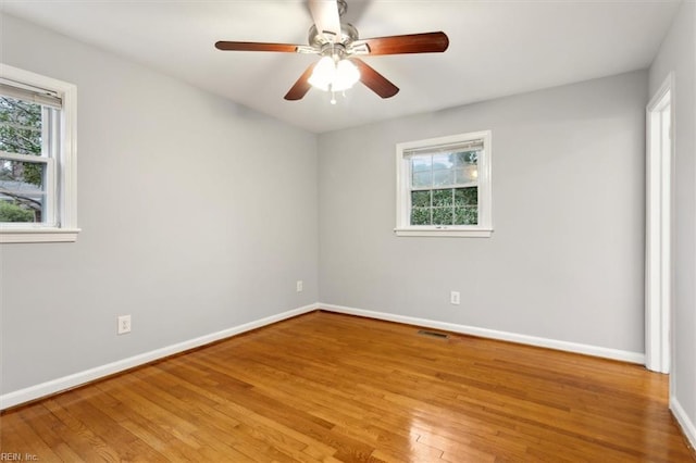 spare room featuring ceiling fan, plenty of natural light, and wood-type flooring