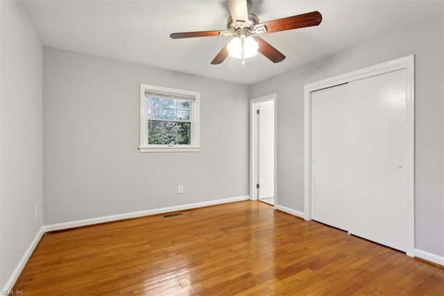 unfurnished bedroom featuring ceiling fan, wood-type flooring, and a closet