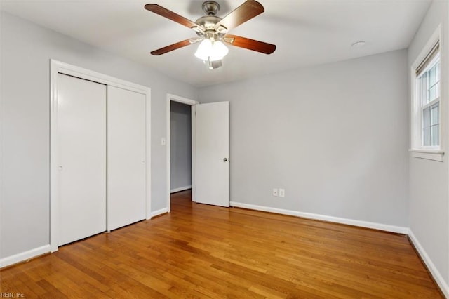 unfurnished bedroom with ceiling fan, a closet, and light hardwood / wood-style floors